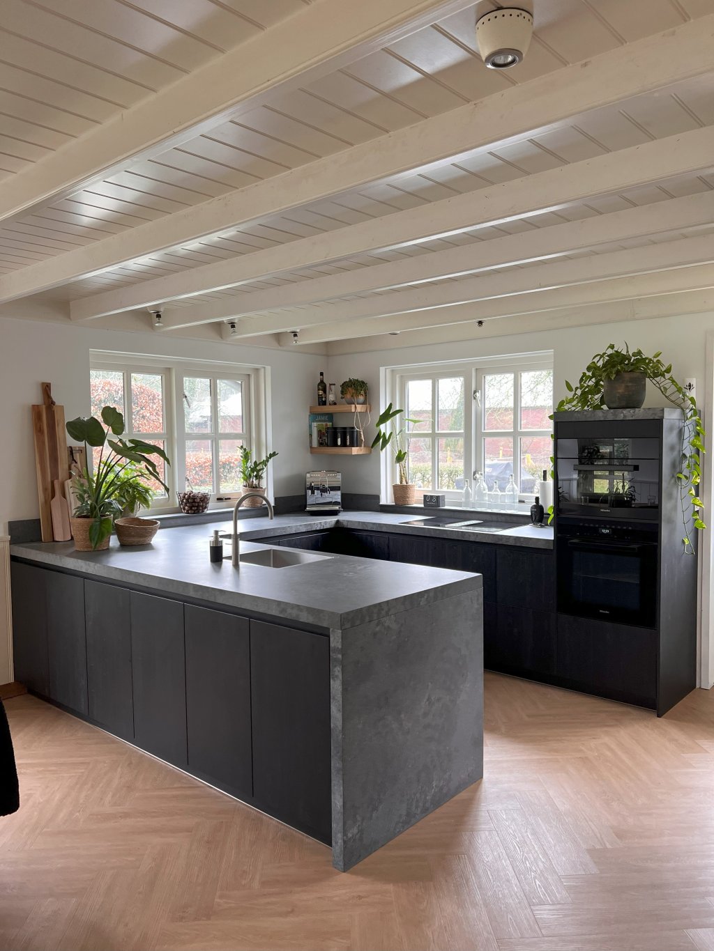 Wiardus keuken met een composiet betonnen blad en zwarte kastjes.